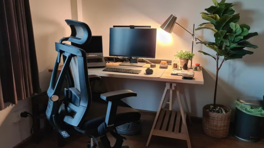 Desk setup and ergonomic chair in dimly lit room