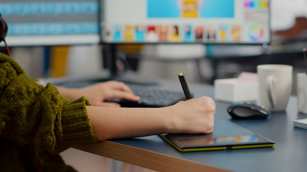 Woman using stylus and drawing pad with a computer