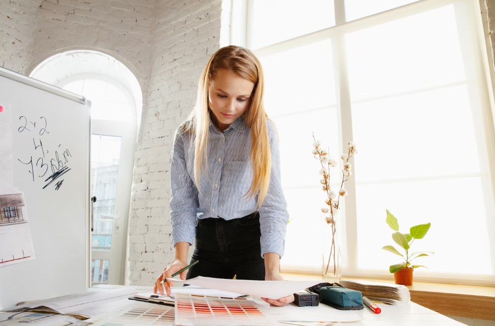 a blond female interior designer with long hair choosing colors